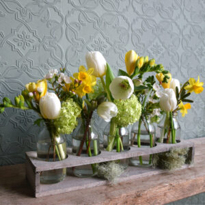 Sample of luxury springtime bottles, a tray of 5 small milk bottles filled with spring flowers. Available to order from Kensington Flowers London