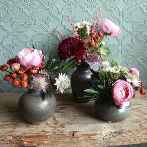 Photo showing a sample image of a trio of pots, filled with seasonal flowers. Available to order from Kensington Flowers London