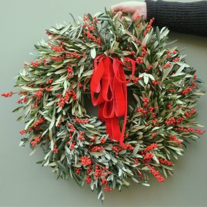 Photo showing a sample of The George Christmas wreath simply olive foliage with fresh red ilex berries available to order from Kensington Flowers London