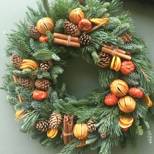 Sample of The Luxury Victoria Christmas door wreath, mixed pines with dried orange fruits, pine cones and cinnamon sticks available to order from Kensington flowers London